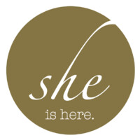 she is here Logo